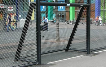 Stainless steel cable mesh are mounted to a black steel frame to create a ball catcher.